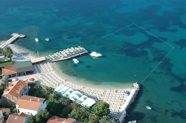 Plaža Raffaello (Topla) u Herceg Novom — pješčana plaža sa suncobranima